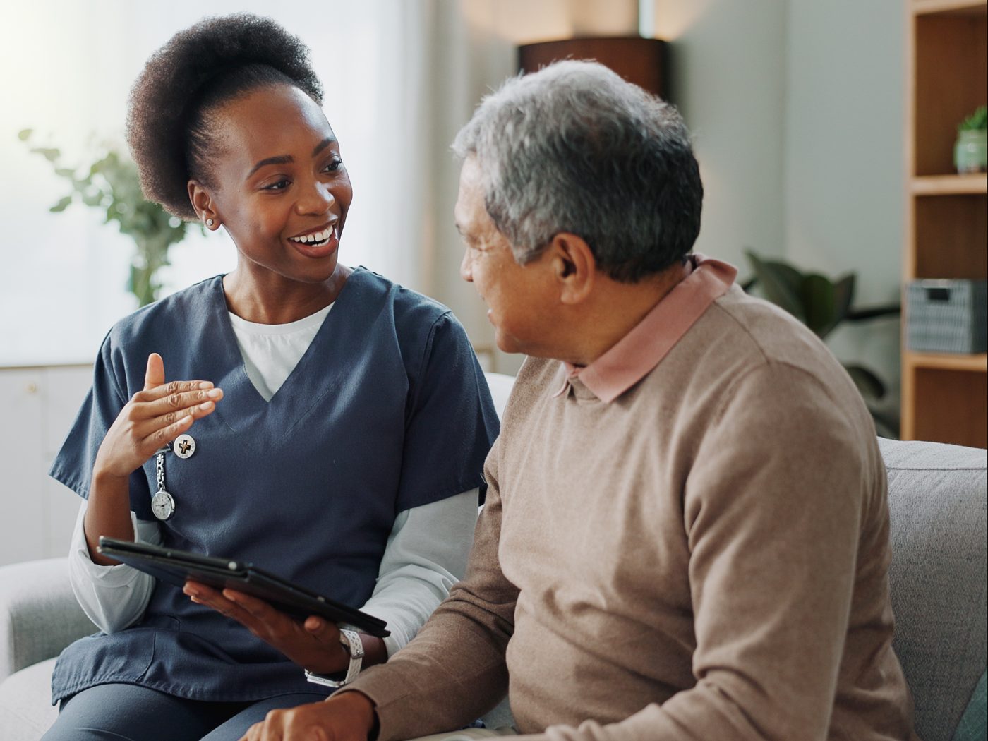 A SteadiCare caregiver talking with an older man in his living room